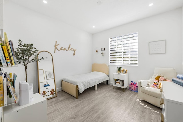 bedroom with light wood finished floors and recessed lighting