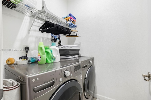 washroom featuring laundry area, baseboards, and washing machine and clothes dryer