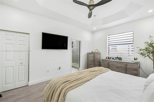 bedroom featuring baseboards, ceiling fan, light wood-type flooring, recessed lighting, and a raised ceiling