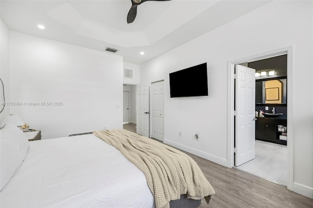 bedroom with visible vents, baseboards, and wood finished floors