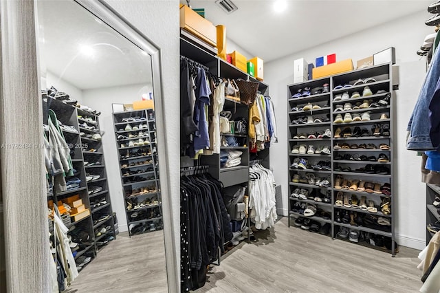 walk in closet with visible vents and wood finished floors