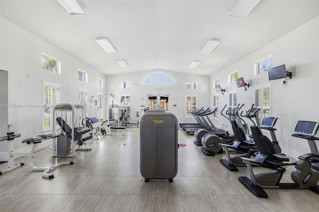 exercise room featuring plenty of natural light, high vaulted ceiling, and baseboards