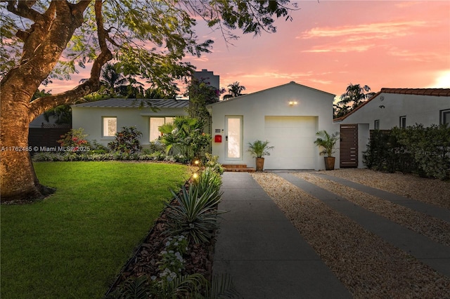 view of front of property with a front lawn, stucco siding, metal roof, a garage, and a standing seam roof