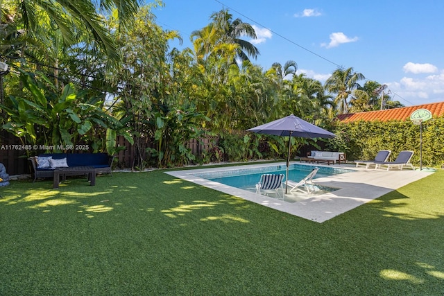 pool featuring a patio area, a yard, outdoor lounge area, and a fenced backyard