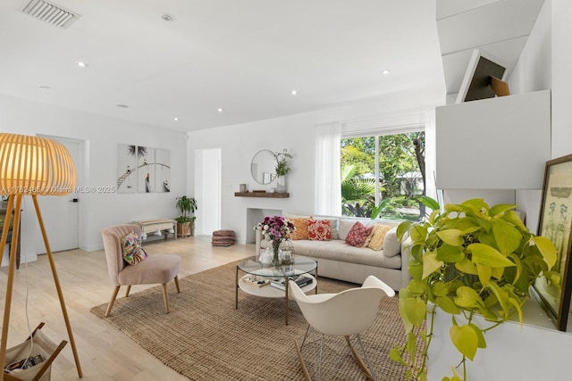 living room with visible vents, recessed lighting, and wood finished floors