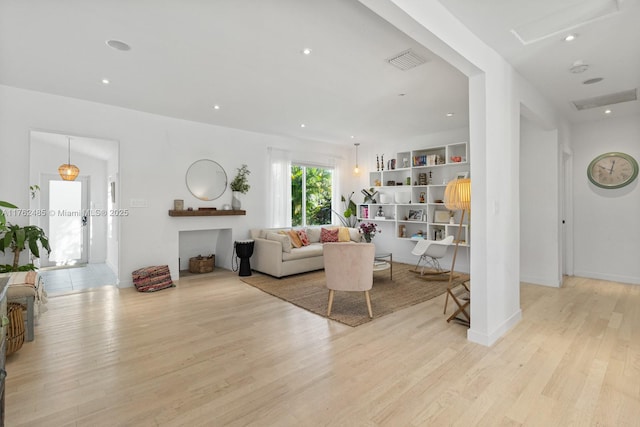 living room featuring recessed lighting, visible vents, baseboards, and light wood-style flooring