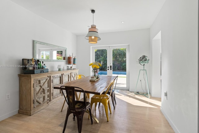 dining area featuring light wood-type flooring, french doors, plenty of natural light, and baseboards