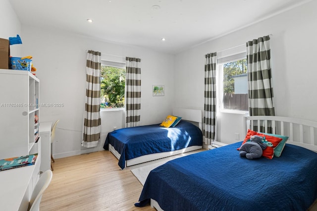 bedroom with recessed lighting, baseboards, and wood finished floors