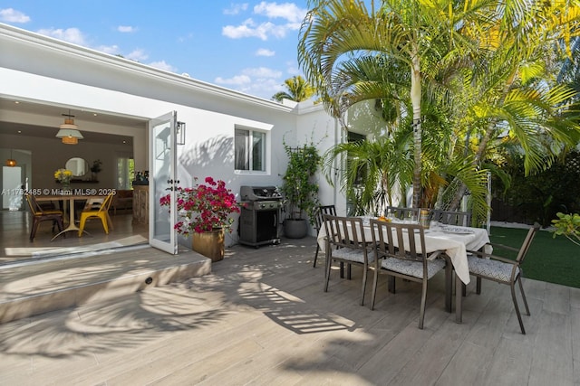 deck featuring outdoor dining area and area for grilling