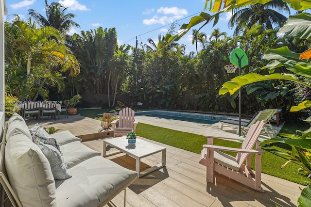 view of patio with an outdoor pool, a wooden deck, outdoor lounge area, and fence