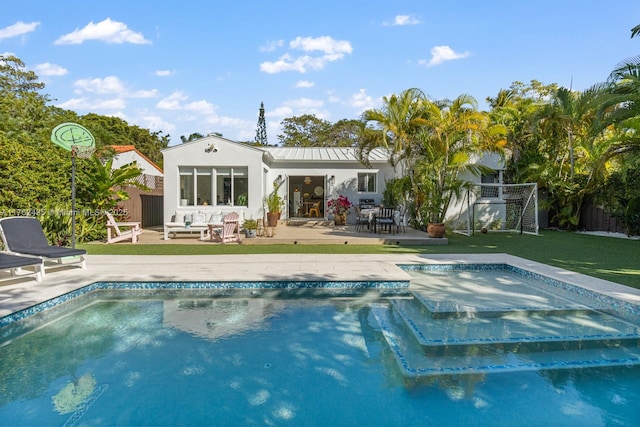 back of house with a jacuzzi, fence, metal roof, an outdoor pool, and a patio