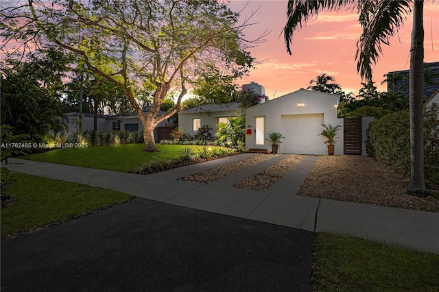 view of front of home with stucco siding, an attached garage, concrete driveway, and a front lawn