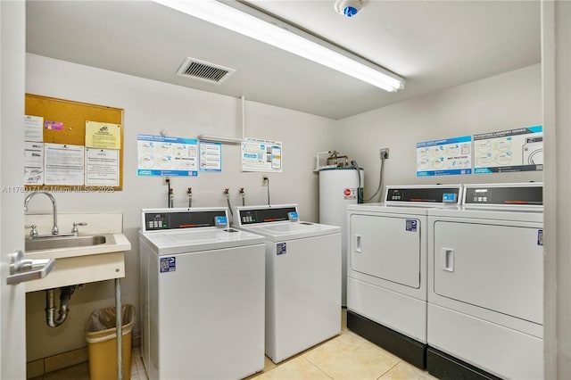 common laundry area with light tile patterned floors, visible vents, washer and dryer, and electric water heater