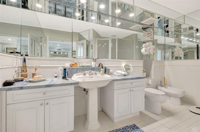 bathroom with tile patterned floors, decorative backsplash, toilet, and a bidet