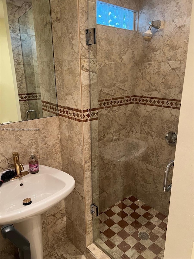 full bathroom with backsplash, a stall shower, and a sink