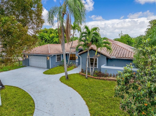 view of front of property with stucco siding, driveway, a tile roof, and a garage