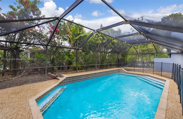 pool featuring glass enclosure, a patio area, and fence