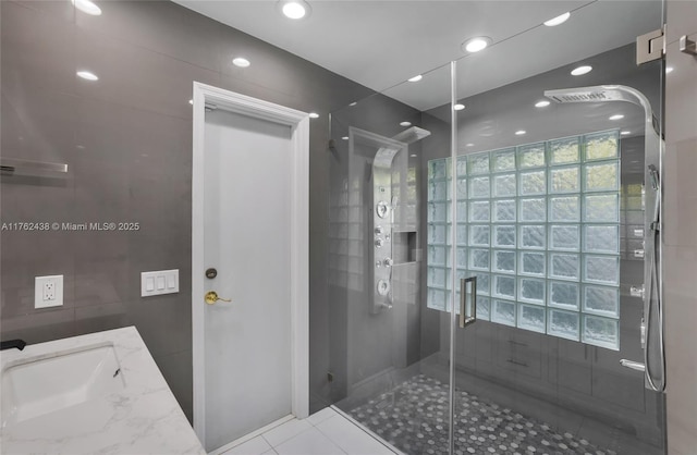 bathroom featuring a shower stall, recessed lighting, tile patterned floors, tile walls, and a sink