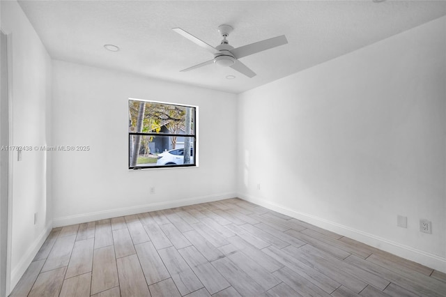 spare room featuring baseboards, ceiling fan, and wood finished floors