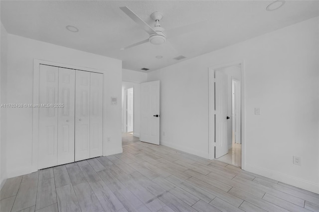 unfurnished bedroom with wood finish floors, a closet, visible vents, and a ceiling fan