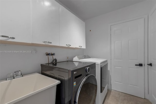 laundry room with a sink, cabinet space, and washer and clothes dryer