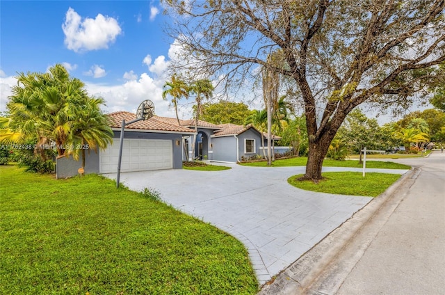 mediterranean / spanish house with curved driveway, a tile roof, a front yard, and stucco siding