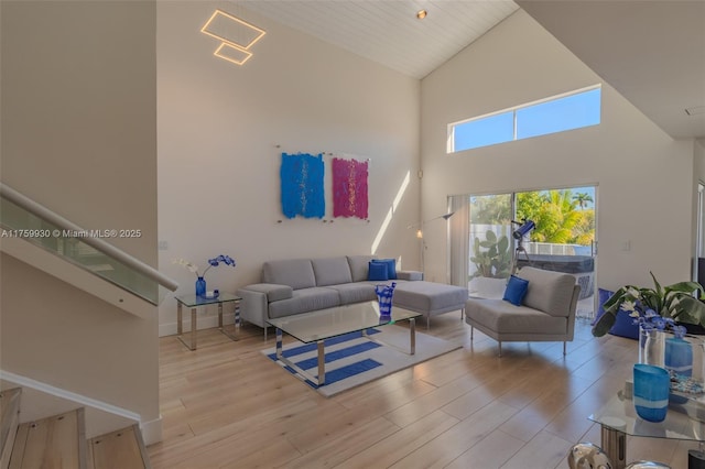 living area with high vaulted ceiling and wood finished floors