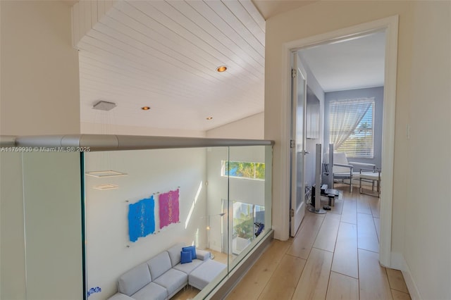 corridor featuring light wood finished floors and baseboards