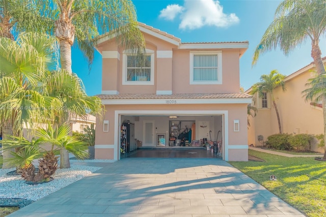 view of front of house with a tiled roof, an attached garage, and stucco siding