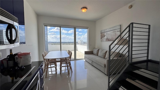 living room featuring stairway and light tile patterned flooring