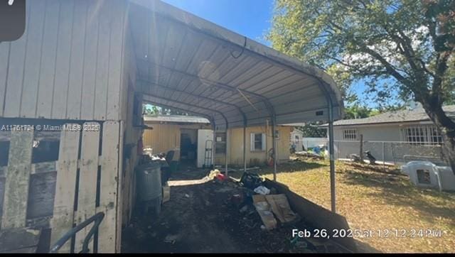 view of vehicle parking with a detached carport and fence