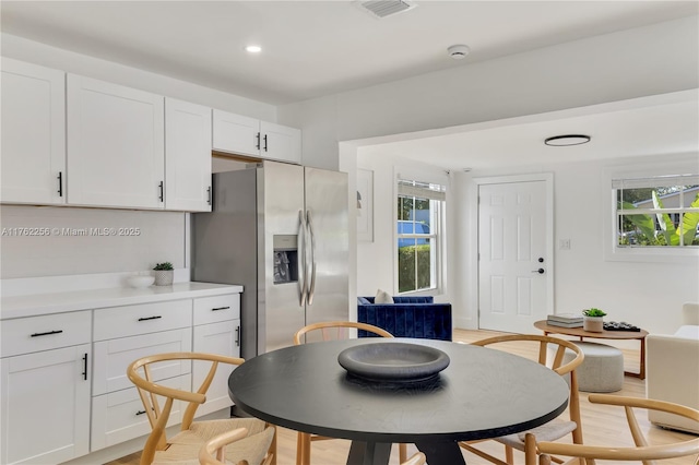 dining space with light wood-style flooring, recessed lighting, and visible vents