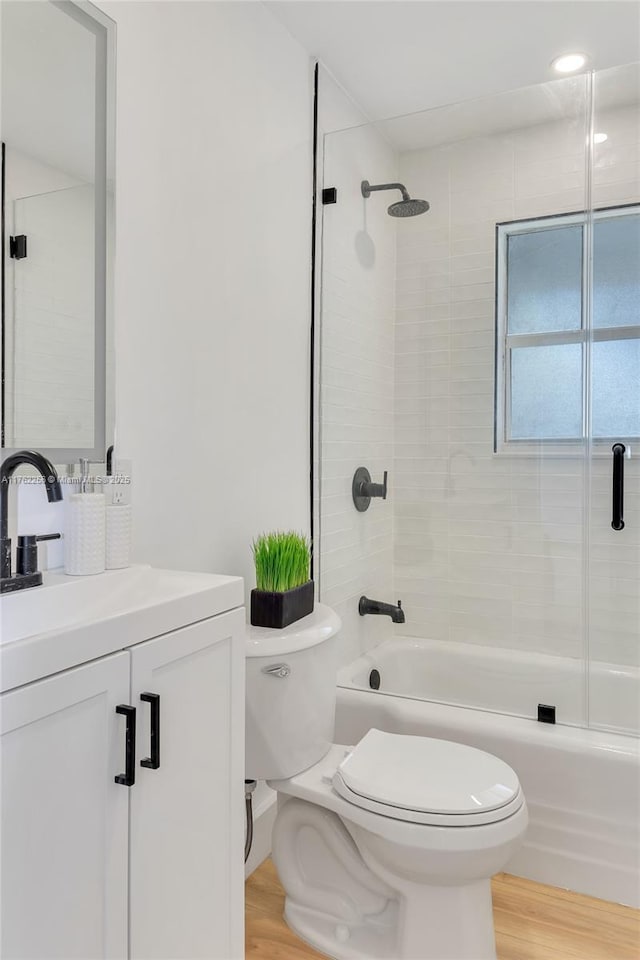 full bath with vanity, toilet, wood finished floors, and shower / bath combination