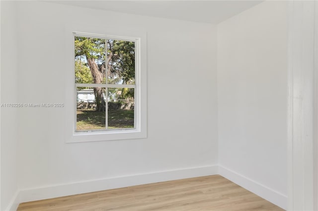 unfurnished room with baseboards and light wood-style flooring