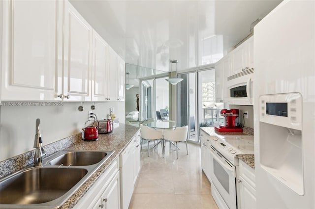 kitchen featuring light tile patterned flooring, white appliances, white cabinetry, and a sink