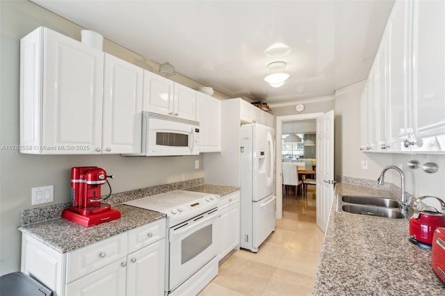 kitchen featuring light stone countertops, light tile patterned floors, white appliances, white cabinetry, and a sink