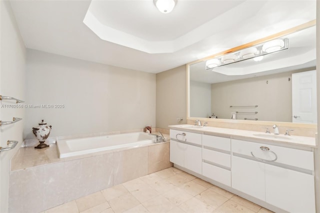 bathroom with a raised ceiling, a bath, double vanity, and a sink