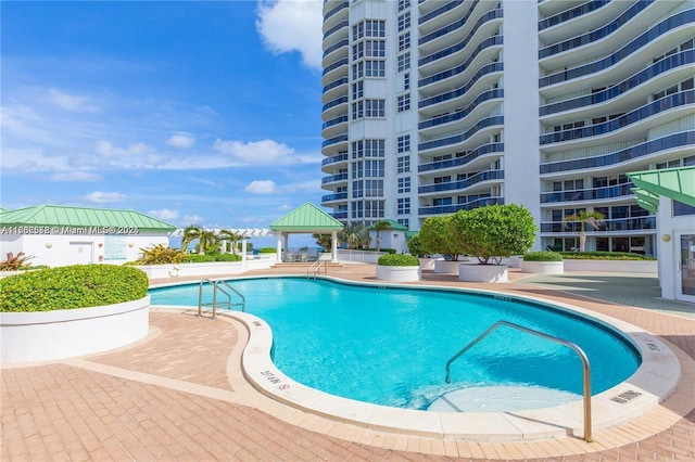 community pool with a gazebo and a patio