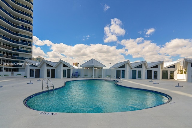 community pool with a gazebo and a patio