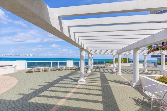 view of patio featuring a pergola and a water view