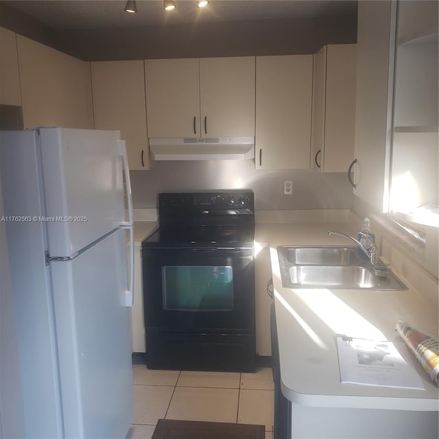 kitchen with under cabinet range hood, a sink, freestanding refrigerator, black / electric stove, and light tile patterned flooring