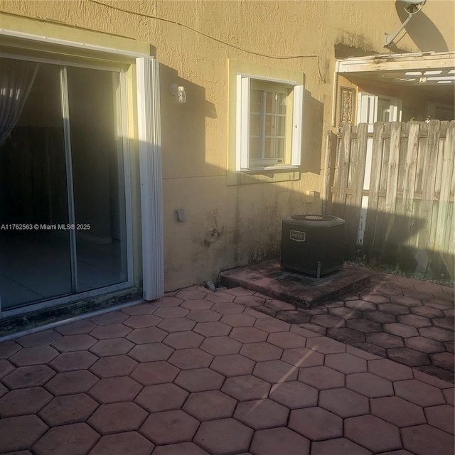 view of patio / terrace with cooling unit and fence