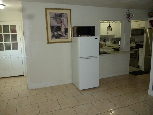 kitchen featuring light countertops, light tile patterned floors, appliances with stainless steel finishes, white cabinetry, and a sink