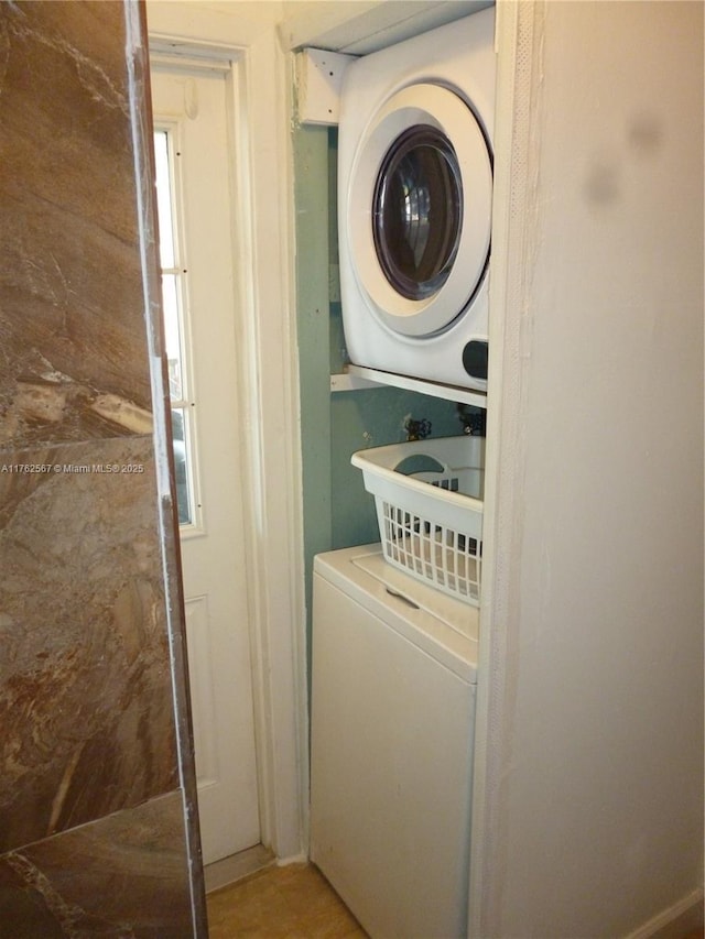 laundry room featuring stacked washer / drying machine and laundry area