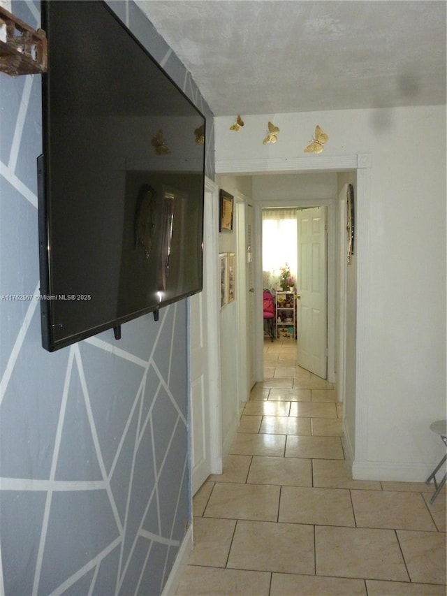 corridor with tile patterned floors and baseboards