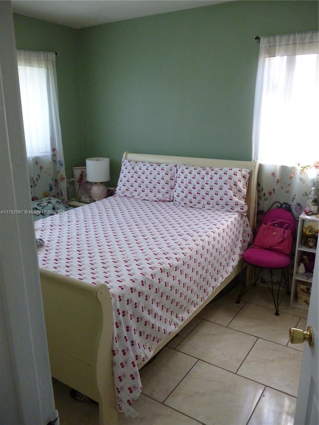 bedroom with tile patterned floors and multiple windows