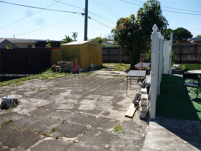 view of patio featuring an outbuilding, a fenced backyard, and a shed