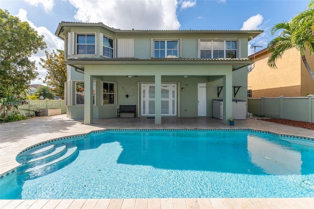 back of property with a fenced in pool, a fenced backyard, a patio area, and stucco siding