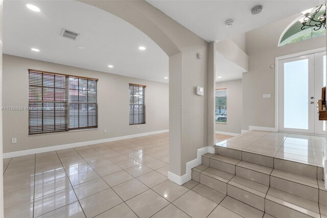 entryway featuring arched walkways, recessed lighting, baseboards, light tile patterned floors, and visible vents