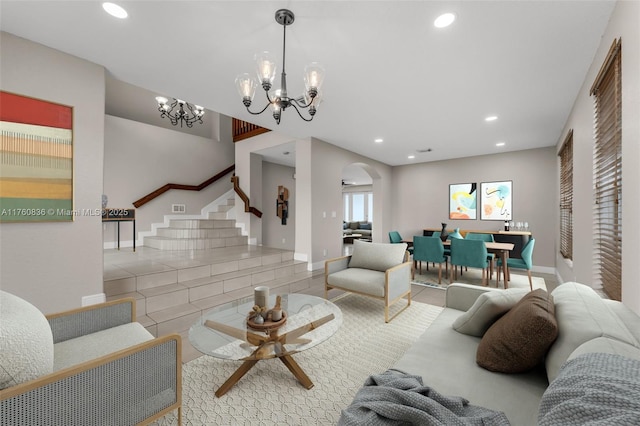 living room with stairs, arched walkways, a notable chandelier, and recessed lighting